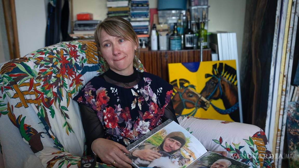 $!Yuliia Movchan, la esposa de un militar ucraniano que murió en batalla con las tropas rusas, muestra fotos de su esposo en un estudio de arte en Kiev, Ucrania.