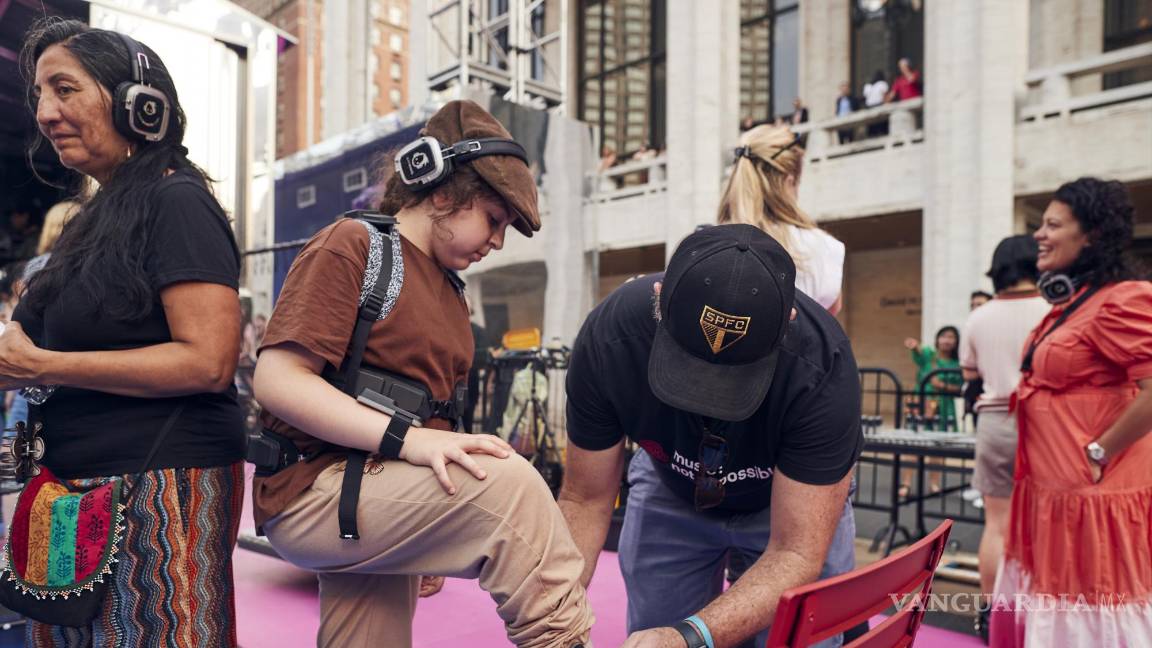 $!Una persona se pone auriculares y las partes conectadas de forma inalámbrica de trajes hápticos para una fiesta disco silenciosa en el Lincoln Center, Nueva York.