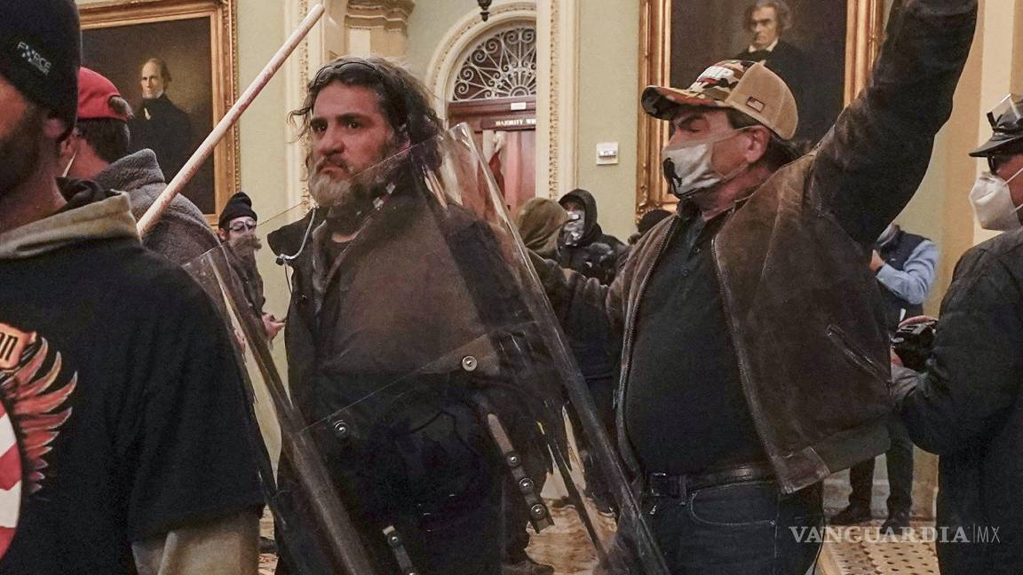 $!Dominic Pezzola, en el centro con escudo policial, son confrontados por agentes de la Policía del Capitolio el miércoles 6 de enero de 2021, en Washington.