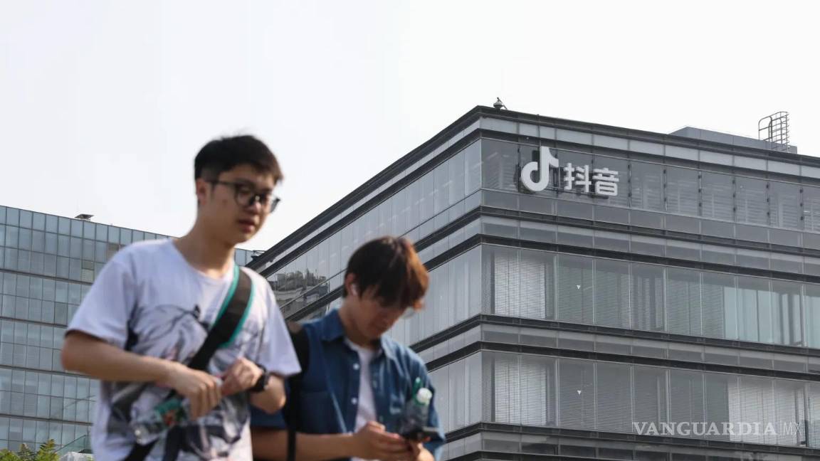 $!Dos jóvenes caminan frente a las oficinas de ByteDance, matriz de TikTok, en Pekín, China.