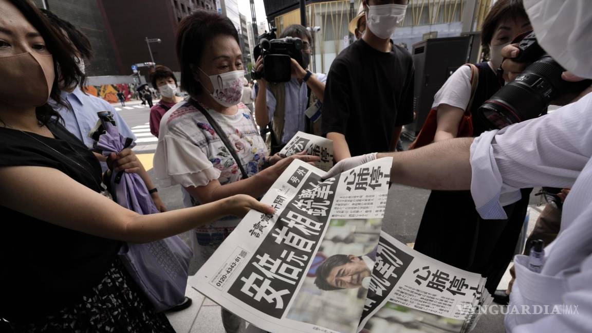 $!Un empleado distribuye ediciones adicionales del periódico Yomiuri Shimbun que reportan que el ex primer ministro japonés Shinzo Abe recibió un disparo, el viernes 8 de julio de 2022, en Tokio. (AP Foto/Eugene Hoshiko)