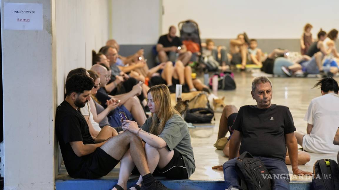 $!Israelíes se sientan en un refugio mientras las sirenas advierten de fuego inminente en Tel Aviv.