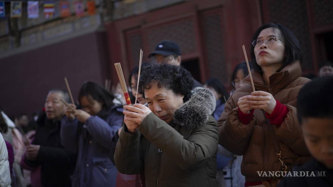 $!Los fieles que sostienen varitas de incienso rezan en el primer día del Año Lunar del Dragón en el Templo Yonghegong Lama en Beijing, China.