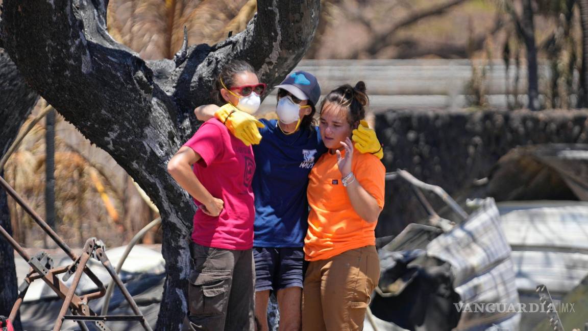 $!Las mujeres se abrazan después de excavar entre los escombros de una casa destruida por un incendio forestal en Lahaina, Hawái.