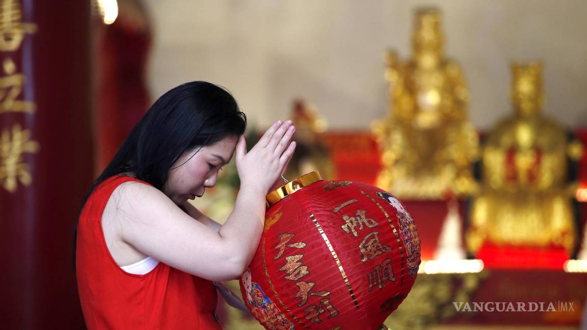 $!Una mujer reza por buena fortuna junto a los dioses chinos para conmemorar el Año Nuevo Lunaren Chinatown, Bangkok, Tailandia.