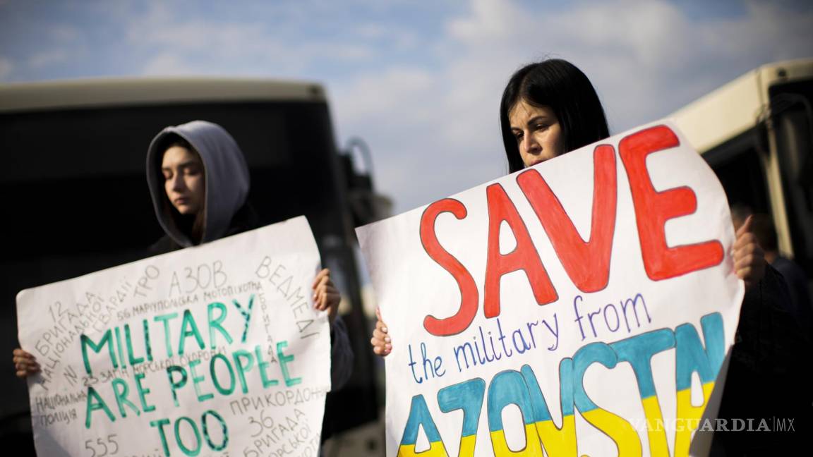 $!Dos mujeres sostienen carteles mientras las personas que huyeron de la planta de acero Azovstal en Mariupol y otras ciudades llegan a Zaporizhzhia, Ucrania.
