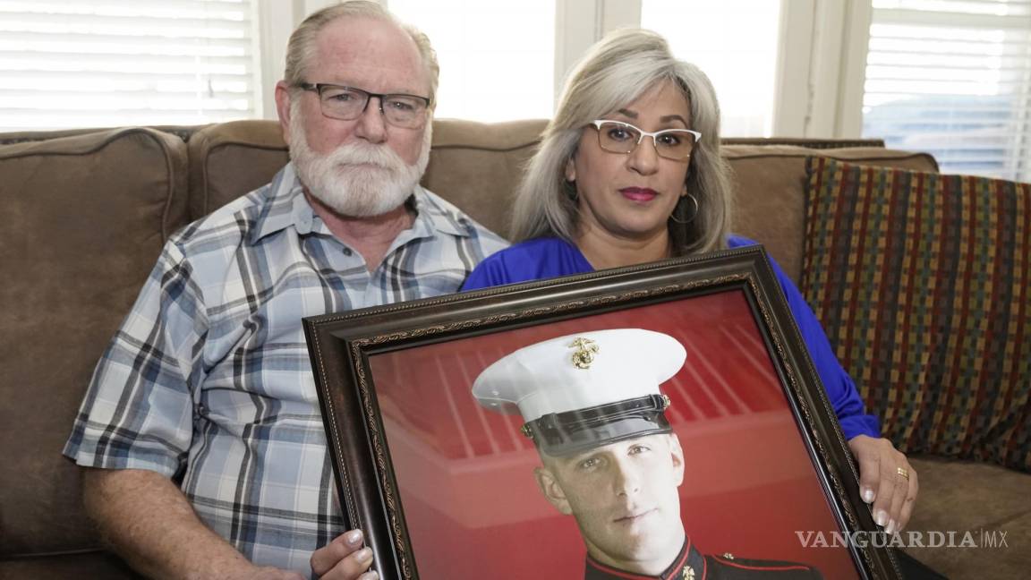 $!Joey y Paula Reed posan para una foto con un retrato de su hijo Trevor Reed, veterano de la Marina y prisionero ruso, en su casa de Fort Worth, Texas.