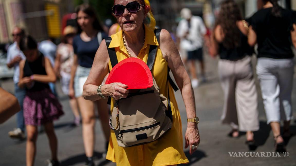 $!Una mujer se abanica en Madrid, España. Los científicos dicen que las sofocantes temperaturas en Europa pudieron haber provocado más de 61,000 muertes.