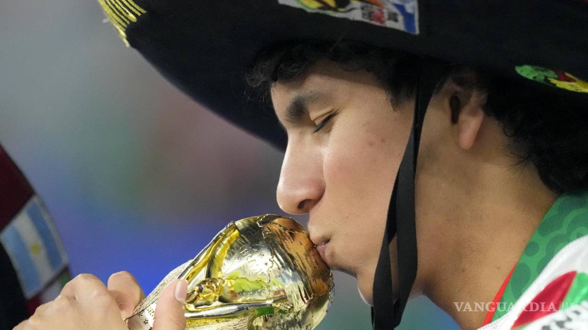 $!Un hincha del equipo de México besa una copia del trofeo de la Copa Mundial durante los calentamientos previos al partido entre México y Polonia.