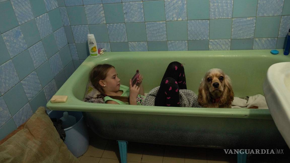$!Zlata-Maria Shlapak se sienta con su cachorro Letti en la bañera al sonar una sirena antiaérea, en el apartamento que renta su familia en Leópolis.