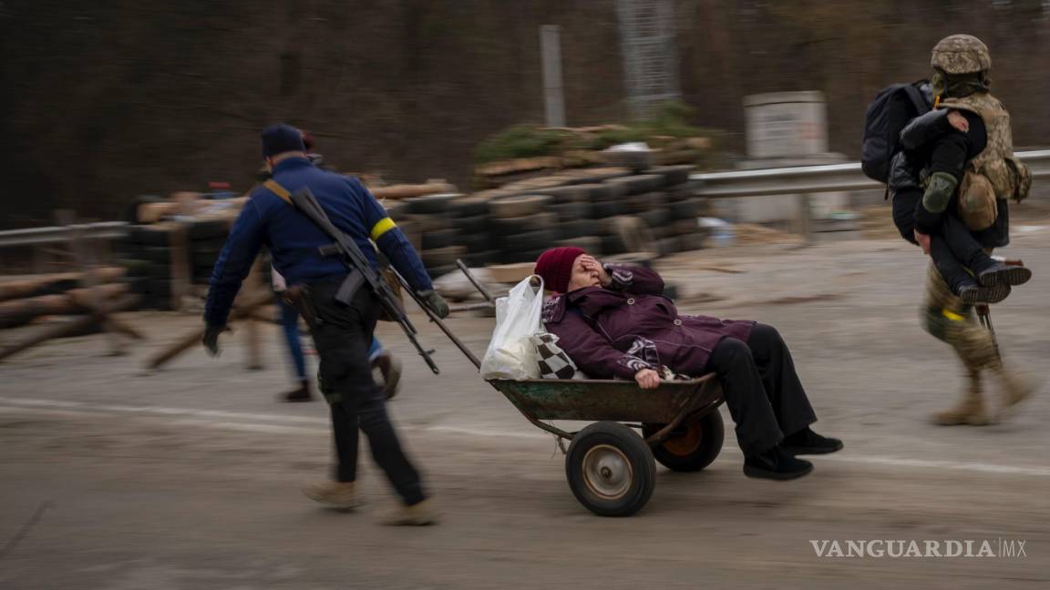 $!Un soldado ucraniano y un miliciano ayudan a una familia a cruzar el río Irpin, a las afueras de Kiev, Ucrania, el 5 de marzo de 2022.