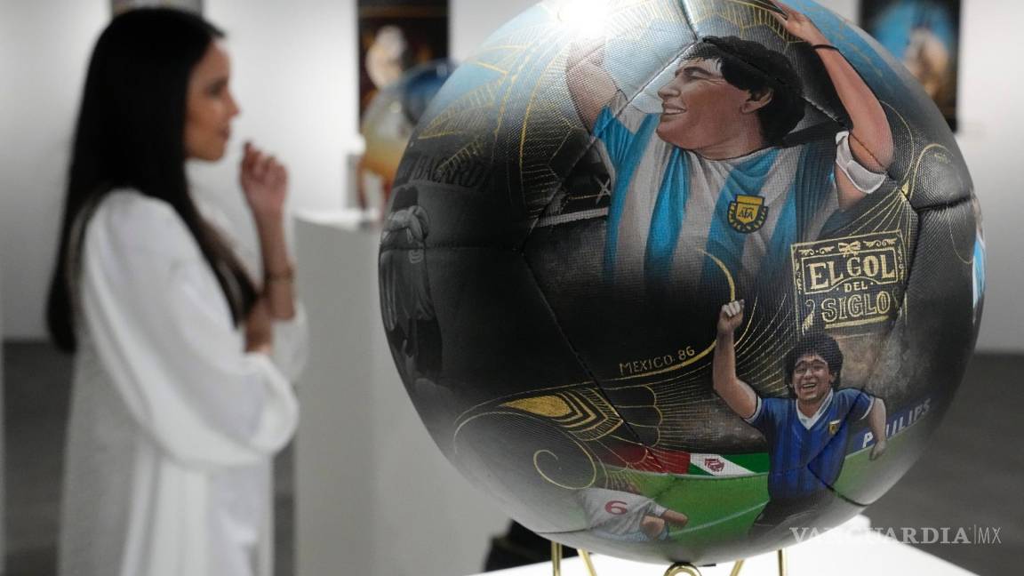 $!La artista paraguaya Lili Cantero, detrás de uno de sus balones pintados, con la imagen del fallecido as argentino Maradona.