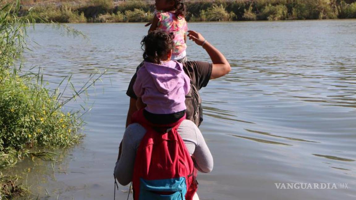 $!Una familia cargando en los hombros a sus dos pequeñas se dispone a cruzar el río Bravo.
