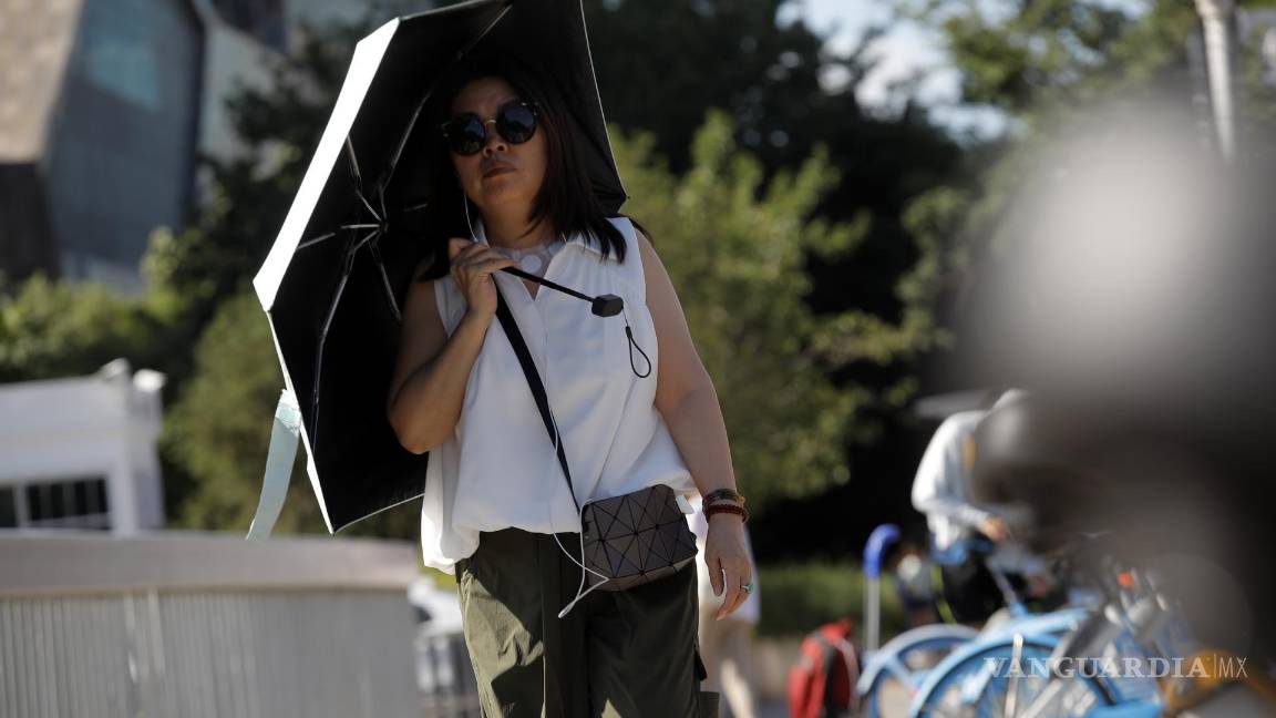 $!Una mujer camina en una calle en Beijing, China.