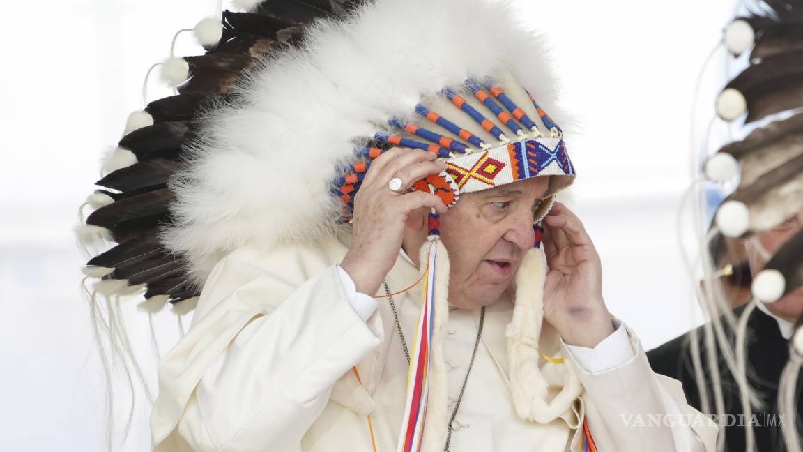 $!El papa Francisco se ajusta un tocado que le fue regalado después de ofrecer disculpas por el papel de la Iglesia católica enlos internados para niños indígenas.