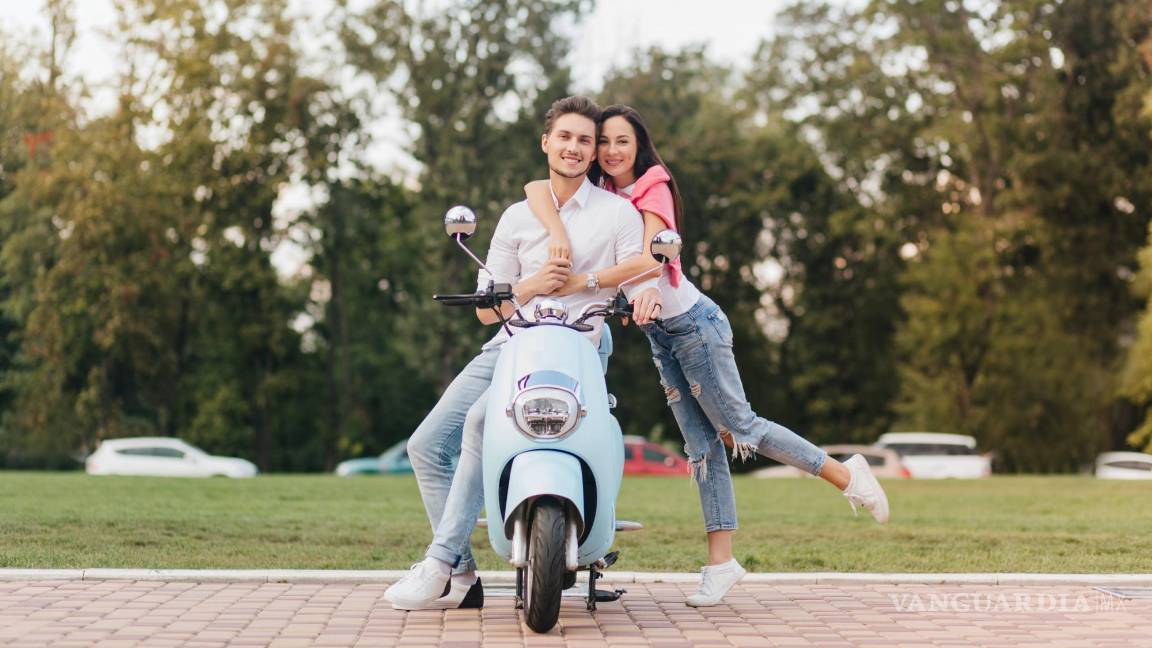 $!Una pareja de adolescentes junto a su vehículo de dos ruedas.