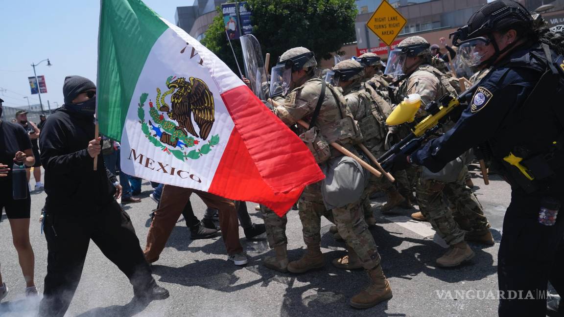 $!Un manifestante con un bandera mexicana se enfrenta a las autoridades durante una protesta tras los operativos migratorios en Los Ángeles.