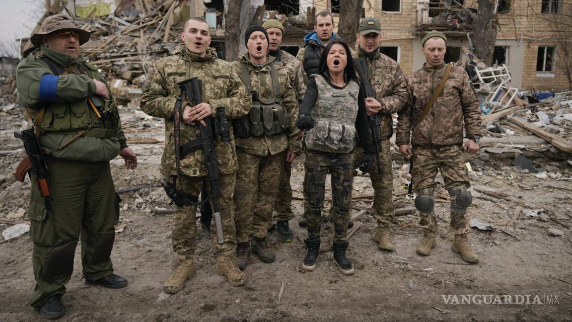 $!Combatientes ucranianos cantan una canción patriótica entre edificios destruidos en los combates entre fuerzas rusas y ucranianas en Borodyanka, Ucrania.