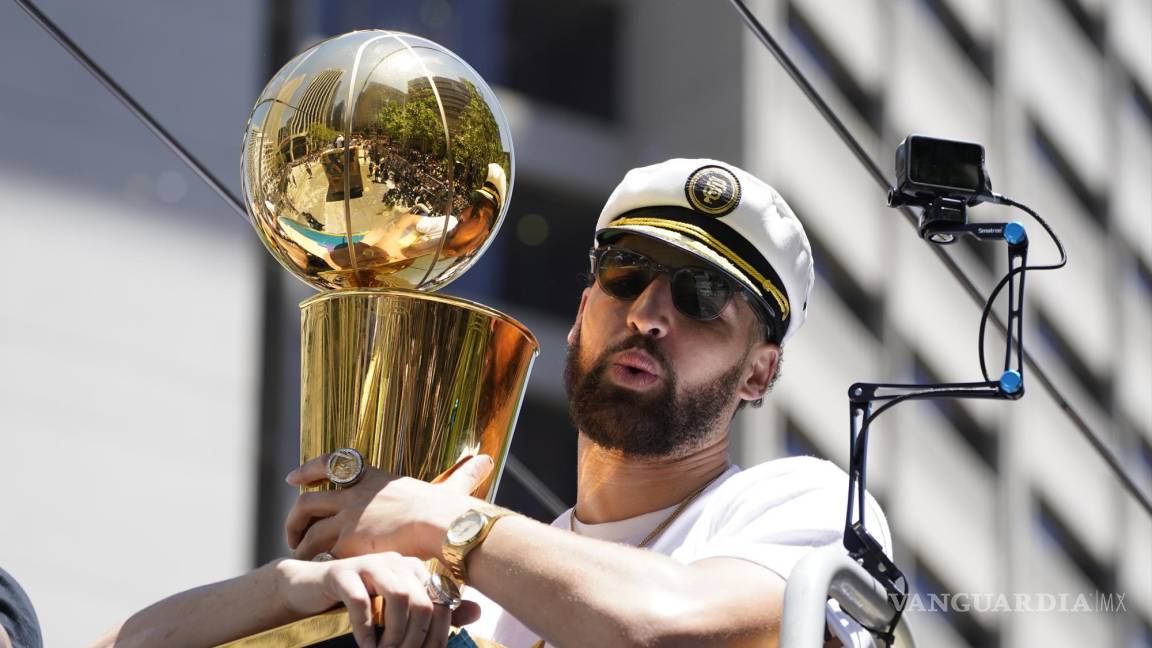 $!Klay Thompson porta una gorra de capitán y sostiene el trofeo de campeones de la NBA, durante el recorrido del desfile de celebración del título de la NBA de los Warriors de Golden State, el lunes 20 de junio de 2022, en San Francisco. (AP Foto/Eric Risberg)