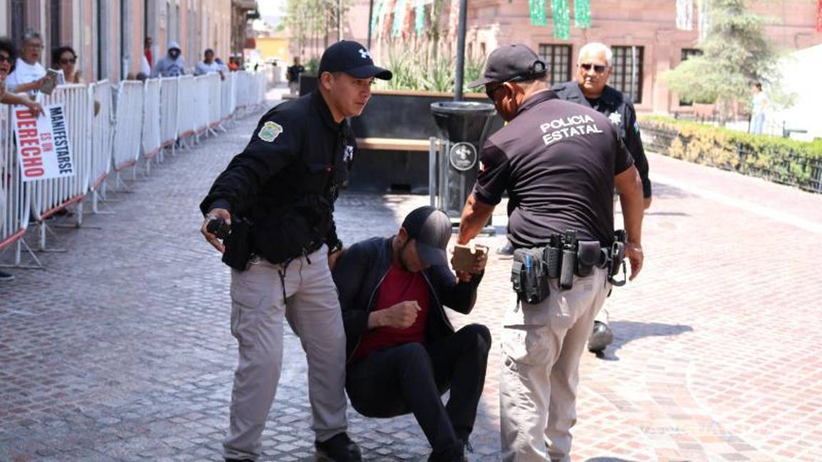 $!Policías del Palacio de Gobierno detienen con violencia al joven activista Jonathan Palacios después de que cruzara las vallas que cercaban la plaza.