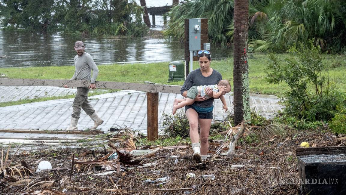 $!Una familia supervisa los destrozos dejados por el huracán, en Jena, cerca de Keaton Beach, Florida.