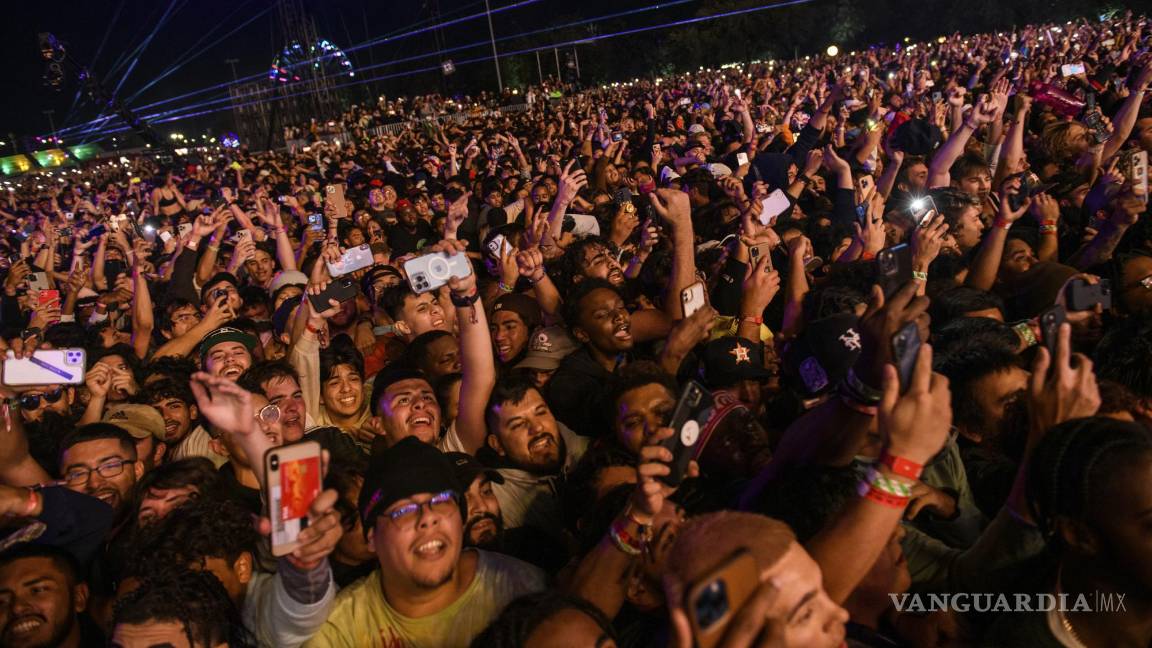 $![a los otros asistentes. The crowd watches as Travis Scott performs at Astroworld Festival at NRG park on Friday]