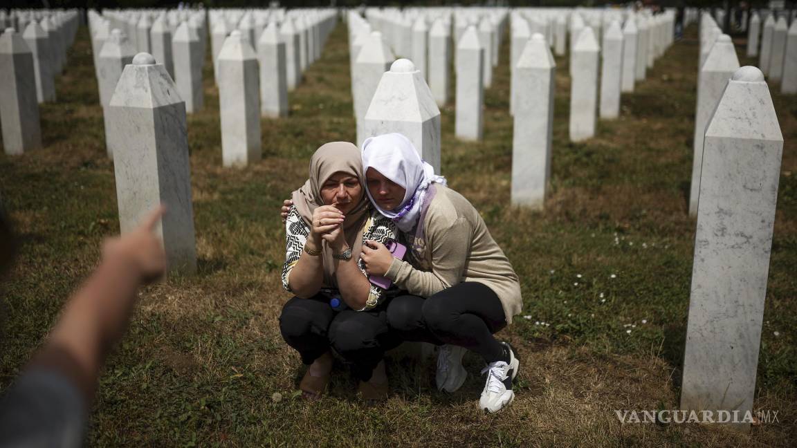 $!Familiares lloran junto a la tumba de su pariente, víctima del genocidio de Srebrenica, antes de la ceremonia de entierro masivo en Potocari, Bosnia.