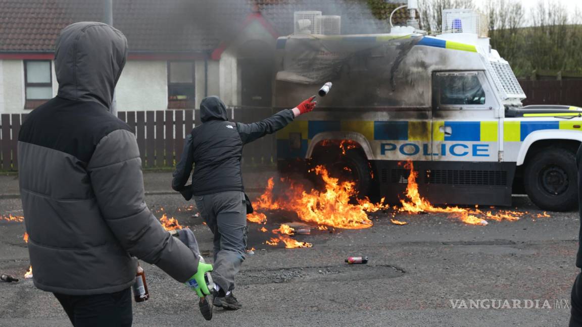 $!Jóvenes enmascarados arrojan cócteles molotov a un Landrover de la policía en Londonderry, Irlanda del Norte.