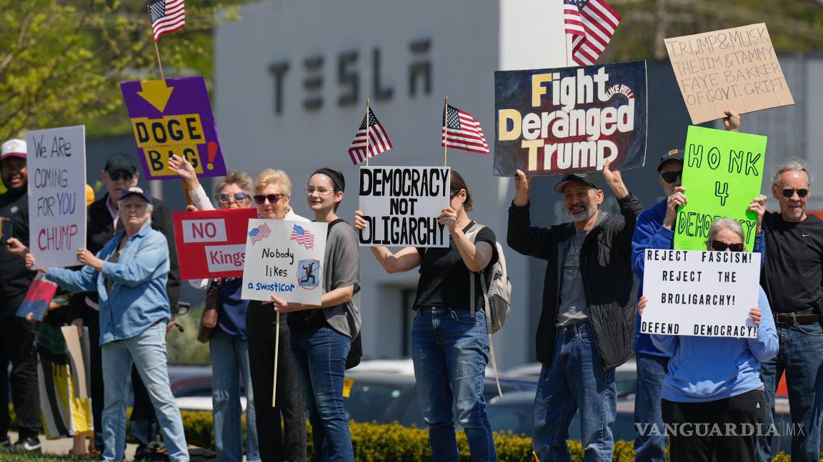 $!Manifestantes protestan contra Elon Musk y los recortes del DOGE frente a un concesionario de Tesla, el sábado 12 de abril de 2025, en Kansas City, Missouri.