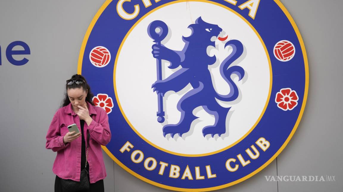 $!Una mujer revisa su teléfono afuera del estadio Stamford Bridge antes del inicio del partido de fútbol de la Premier League inglesa entre Chelsea y Wolverhampton.