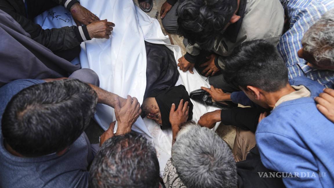 $!Palestinos lloran sobre el cuerpo de Al-Akhras, que murió cuando se dirigía a un centro de ayuda en Gaza, durante su funeral en el Hospital Nasser en Jan Yunis.