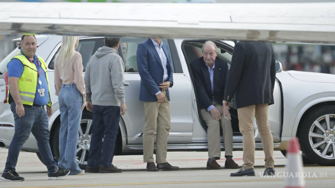 $!El ex rey de España Juan Carlos, segundo a la derecha, se sienta en un automóvil a su llegada en avión privado al aeropuerto de Peinador en Vigo, noroeste de España.