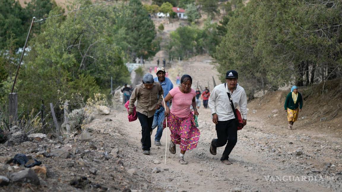 $!La corredora rarámuri Teresa Sánchez está acompañada por residentes mientras compite en la carrera de Arihueta en Cuiteco, México.