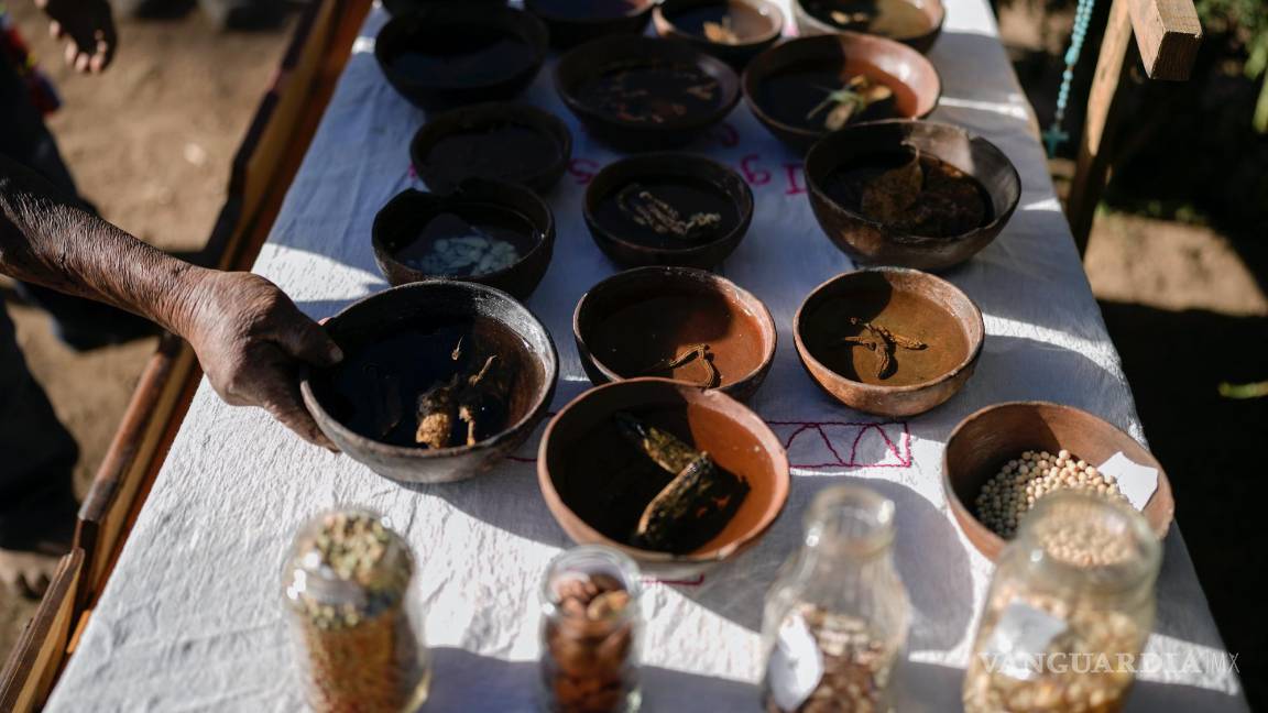 $!Un hombre indígena rarámuri coloca una ofrenda en un altar en la ceremonia sagrada Yúmari en honor de los curas jesuitas Javier Campos y Joaquín Mora.