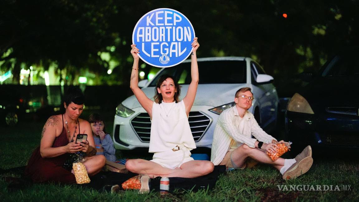 $!La defensora de los derechos reproductivos Kat Duesterhaus con un cartel mientras Joe Biden y Donald Trump, hablan sobre el acceso al aborto. en Miami