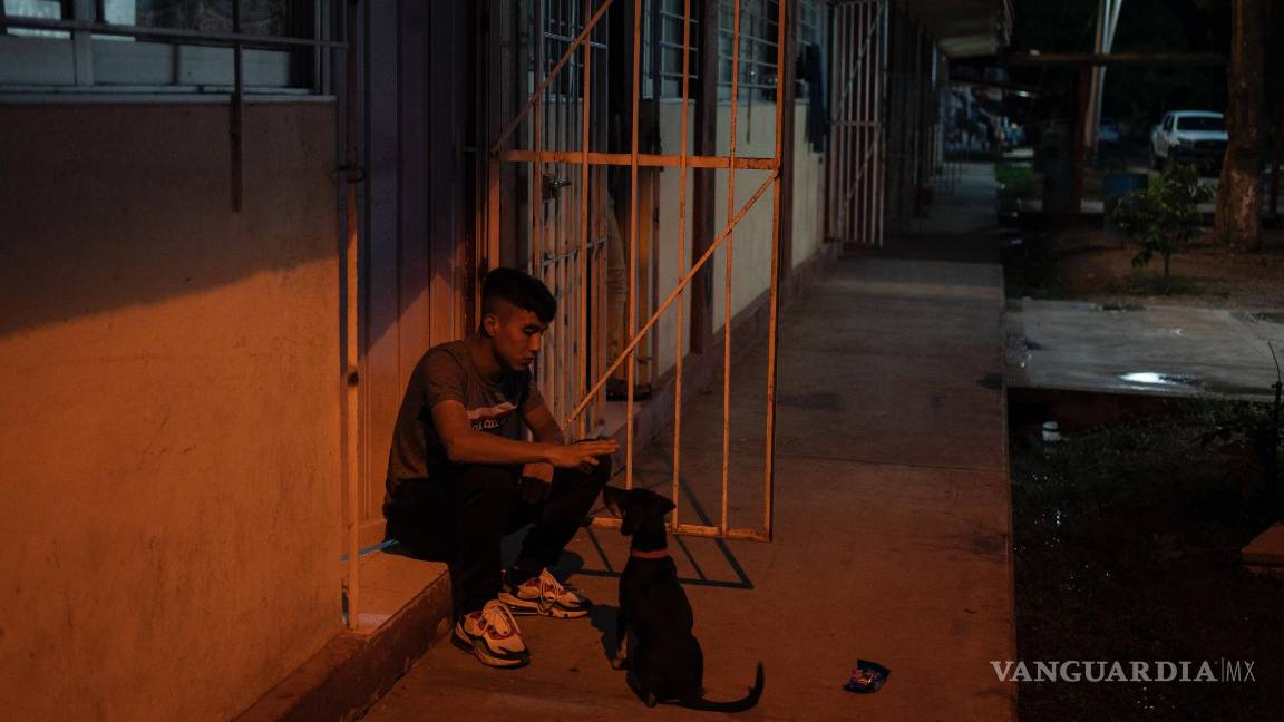 $!Un estudiante juega con su perro fuera de su cuarto en la escuela Normal Rural Raúl Isidro Burgos, en Ayotzinapa, en el estado de Guerrero.