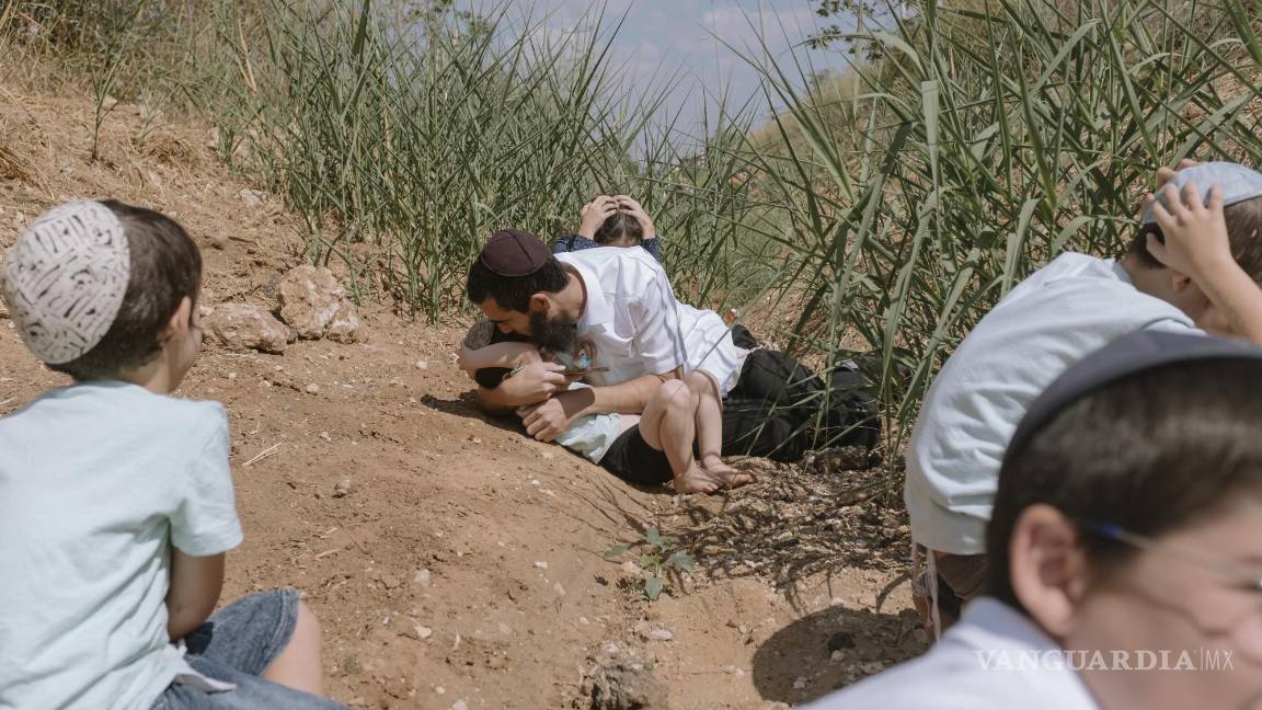 $!Israelíes se refugian al sonar una sirena que advierte que llegan cohetes disparados desde Gaza, en Rehovot, Israel, viernes 13 de octubre de 2023.