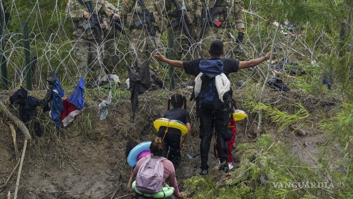 $!Un migrante habla con efectivos de la Guardia Nacional de Texas en la orilla del Río Bravo, vistos desde Matamoros, México, el 11 de mayo de 2023.