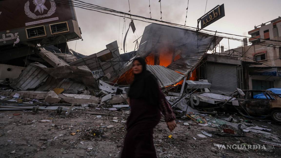 $!Una mujer palestina camina junto a una panadería destruida en el campo de refugiados de Al Nusairat, en el centro de la Franja de Gaza.