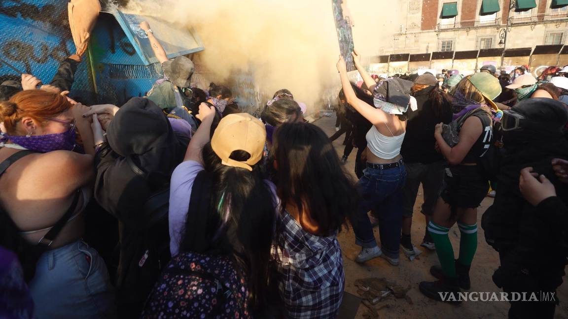 $!Mujeres intentan derribar una valla de acero durante una marcha con motivo del Día Internacional de la Mujer, en Ciudad de México (México).