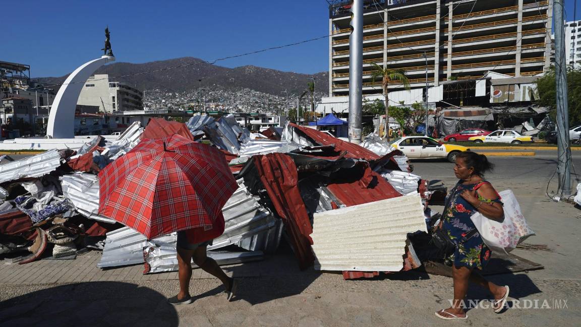 $!Residentes caminan junto a escombros tras la devastación que dejó el paso del huracán Otis, en Acapulco, México, el domingo 12 de noviembre de 2023.