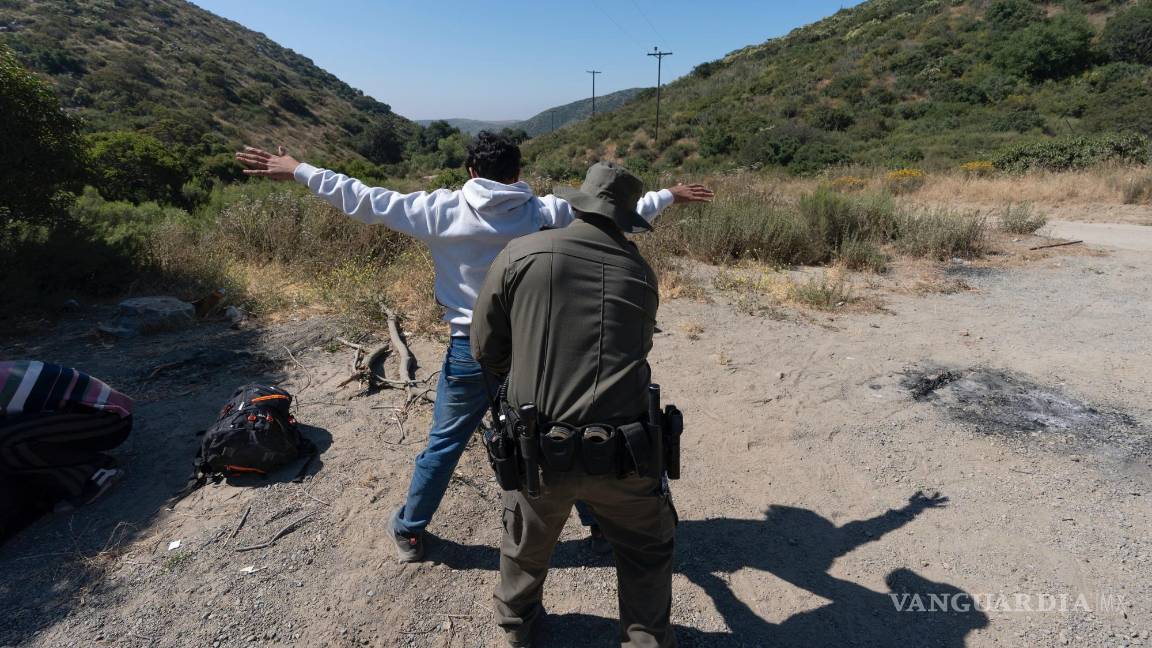 $!Un agente de la Patrulla Fronteriza revisa a un migrante que busca asilo antes de que lo transporten y procesen erca de Dulzura, California.