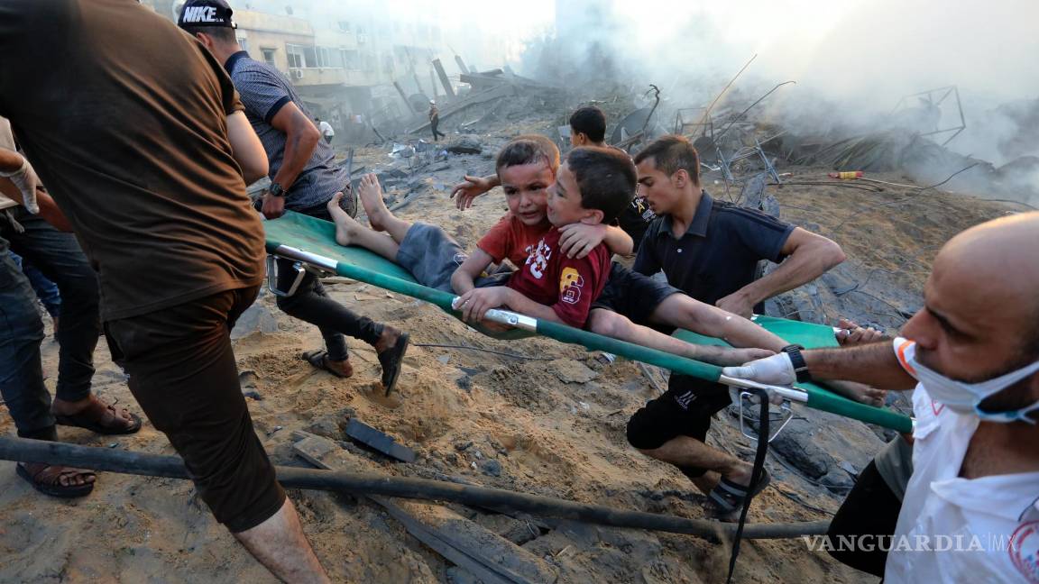 $!Palestinos sacan a dos niños heridos en un ataque aéreo israelí sobre la Ciudad de Gaza, el 25 de octubre de 2023.