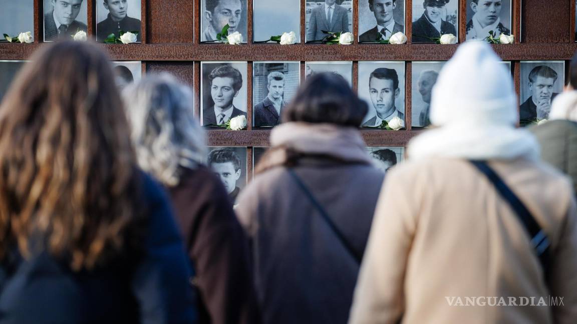 $!Visitantes observan retratos adornados con rosas de las víctimas del Muro de Berlínen Berlín, Alemania.