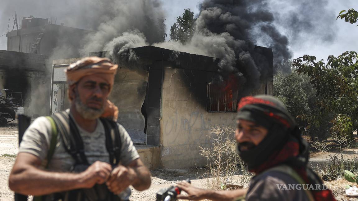 $!Combatientes beduinos, frente a una tienda quemada en Mazraa, durante enfrentamientos entre clanes beduinos y milicias rusas, en el sur de Siria.