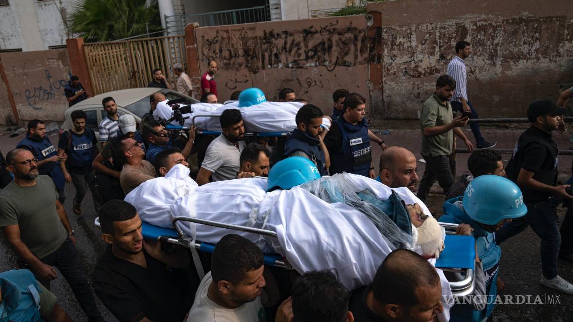 $!Palestinos, entre los que hay reporteros, cargan los cuerpos de dos periodistas palestinos muertos durante un bombardeo israelí en la Ciudad de Gaza.