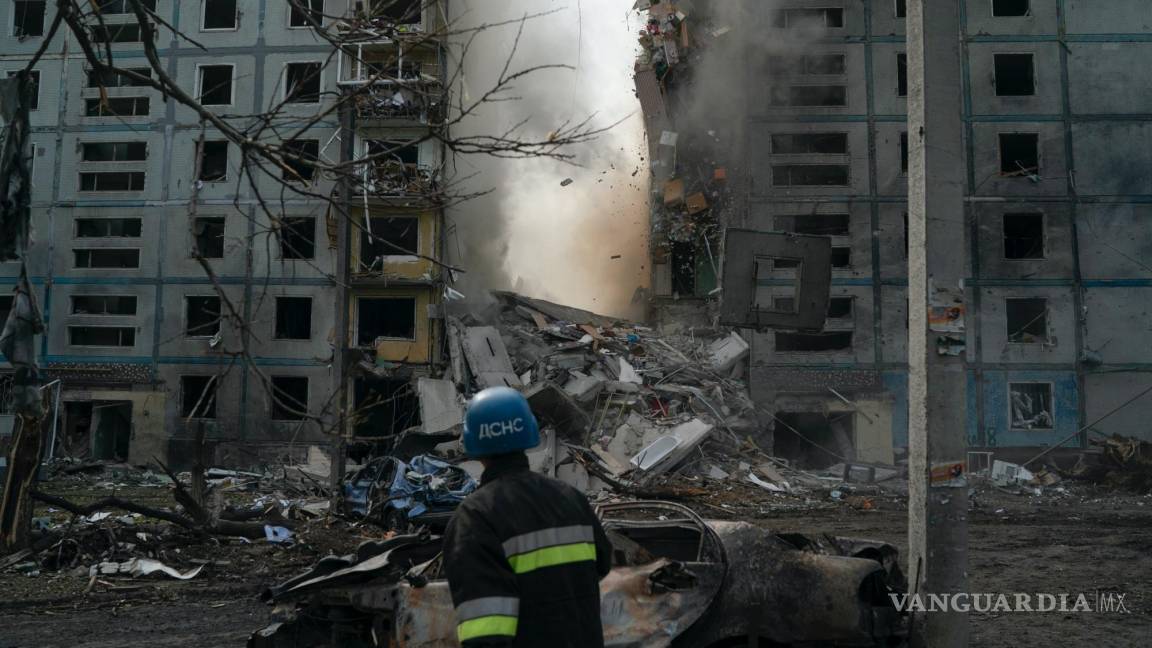 $!Un bombero mira la caída de un muro de un edificio residencial que sufrió daños graves después de un ataque ruso en Zaporiyia, Ucrania.