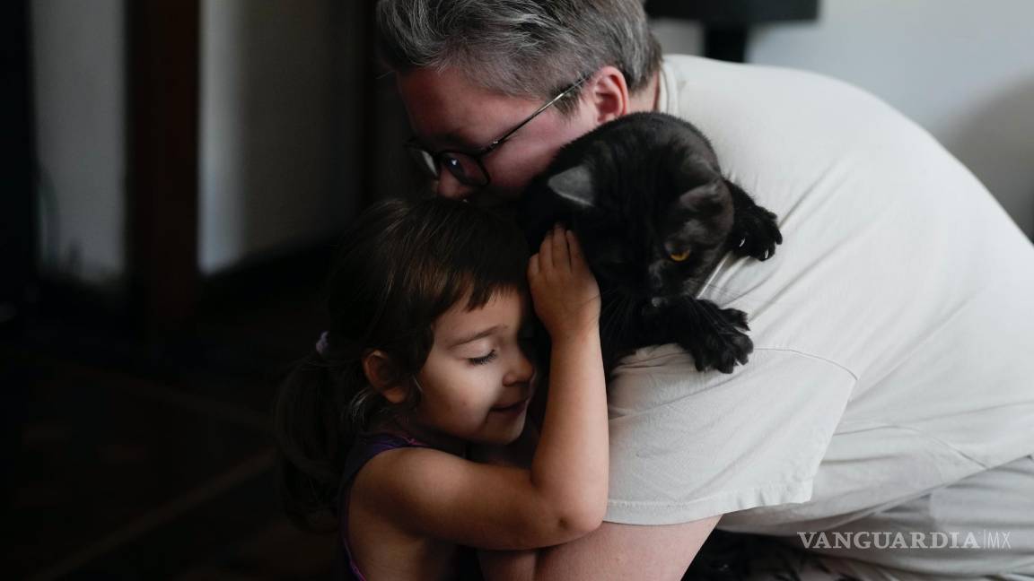 $!Anna Domini y su hija Agata, de 3 años, abrazan a su gato Faust en su casa de Buenos Aires, Argentina.