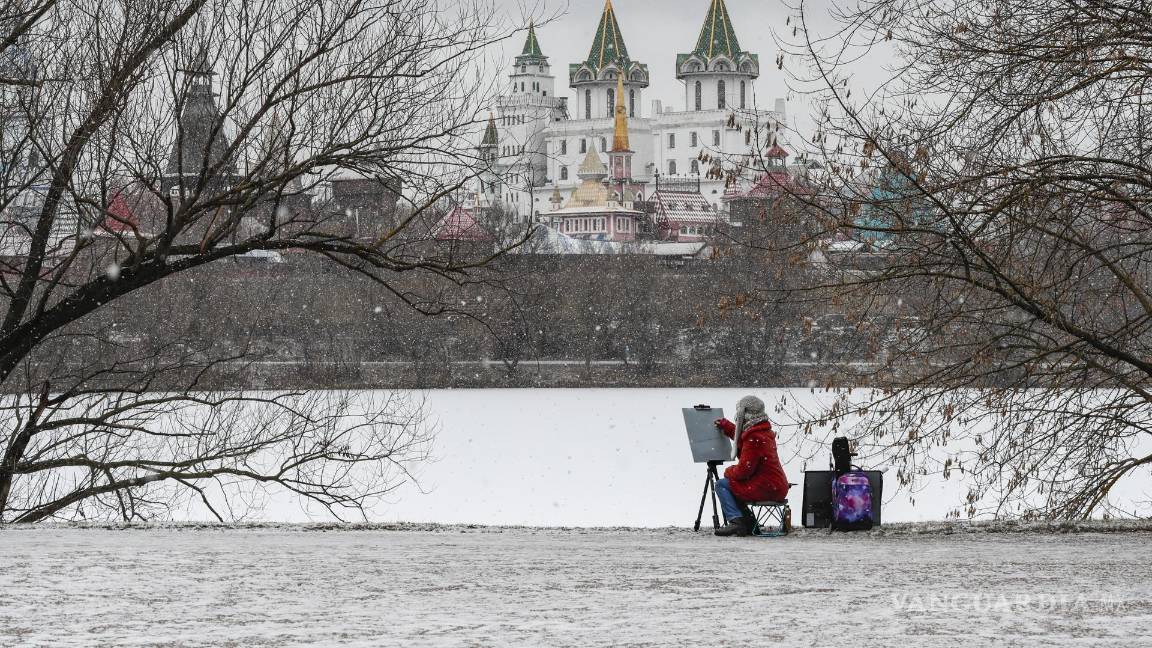 $!Un artista pinta cerca de un estanque congelado frente al Kremlin en Moscú, Rusia Las temperaturas en la región de Moscú bajaron a menos ocho grados Celsius.