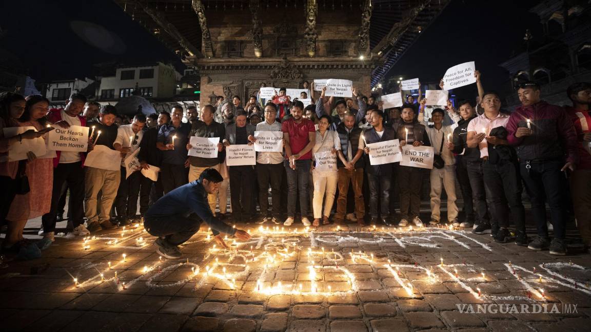 $!Un grupo de estudiantes nepaleses participan en una vigilia con velas para orar por los estudiantes nepaleses que murieron en Israel, en Katmandú, Nepal.